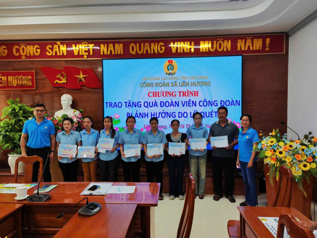 Anh Nguyễn Hòa – Chủ tịch Công đoàn cơ sở Xí nghiệp May Tuy Phong (bên trái) trao hỗ trợ người lao động bị thiệt hại do lũ lụt. Ảnh: Đức Lâm