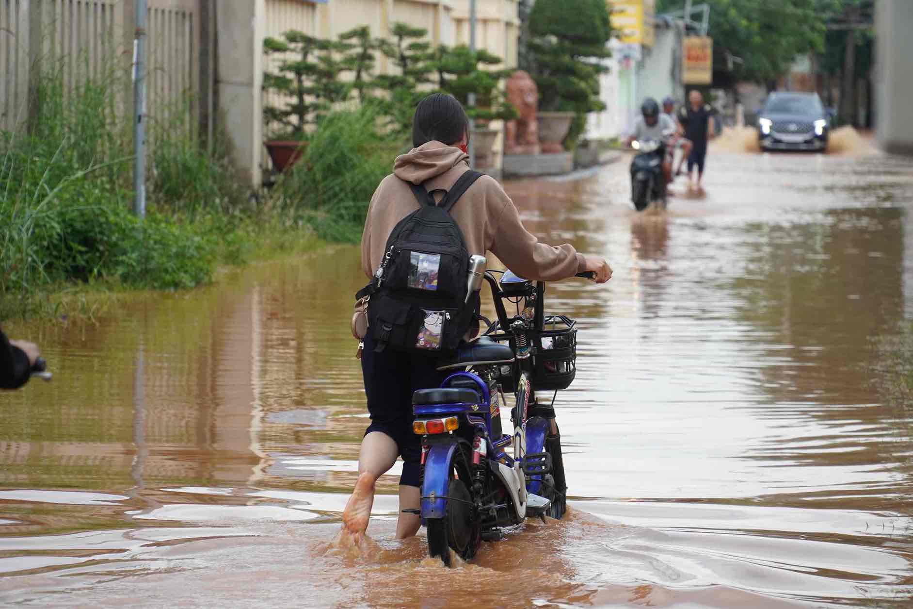 Ngập tại phường Phước Tân ảnh hưởng việc đi lại, học tập của học sinh. Ảnh tư liệu: HAC