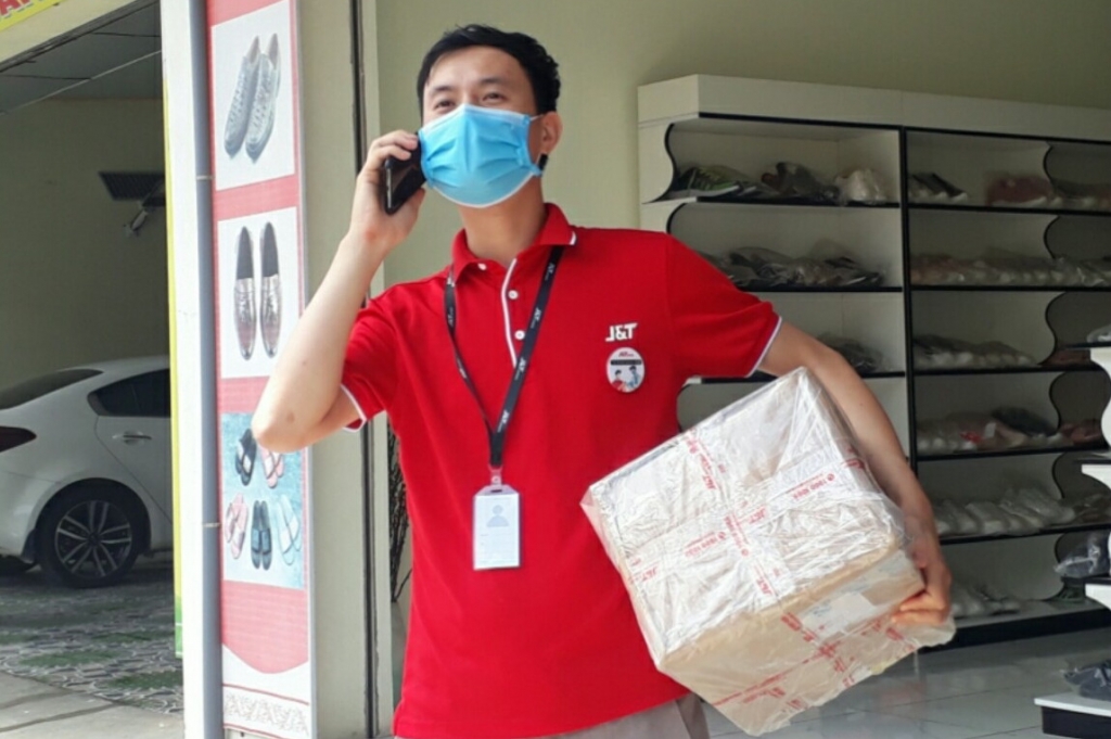 Các shipper J&T Express được tiêm phòng và có đeo huy hiệu đã tiêm vaccine ngừa Covid-19