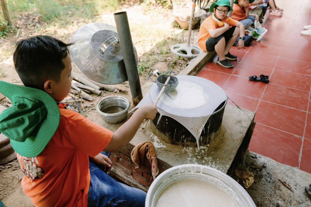 Các em nhỏ được trải nghiệm các nghề làm bánh tráng truyền thống Túy Loan của địa phương