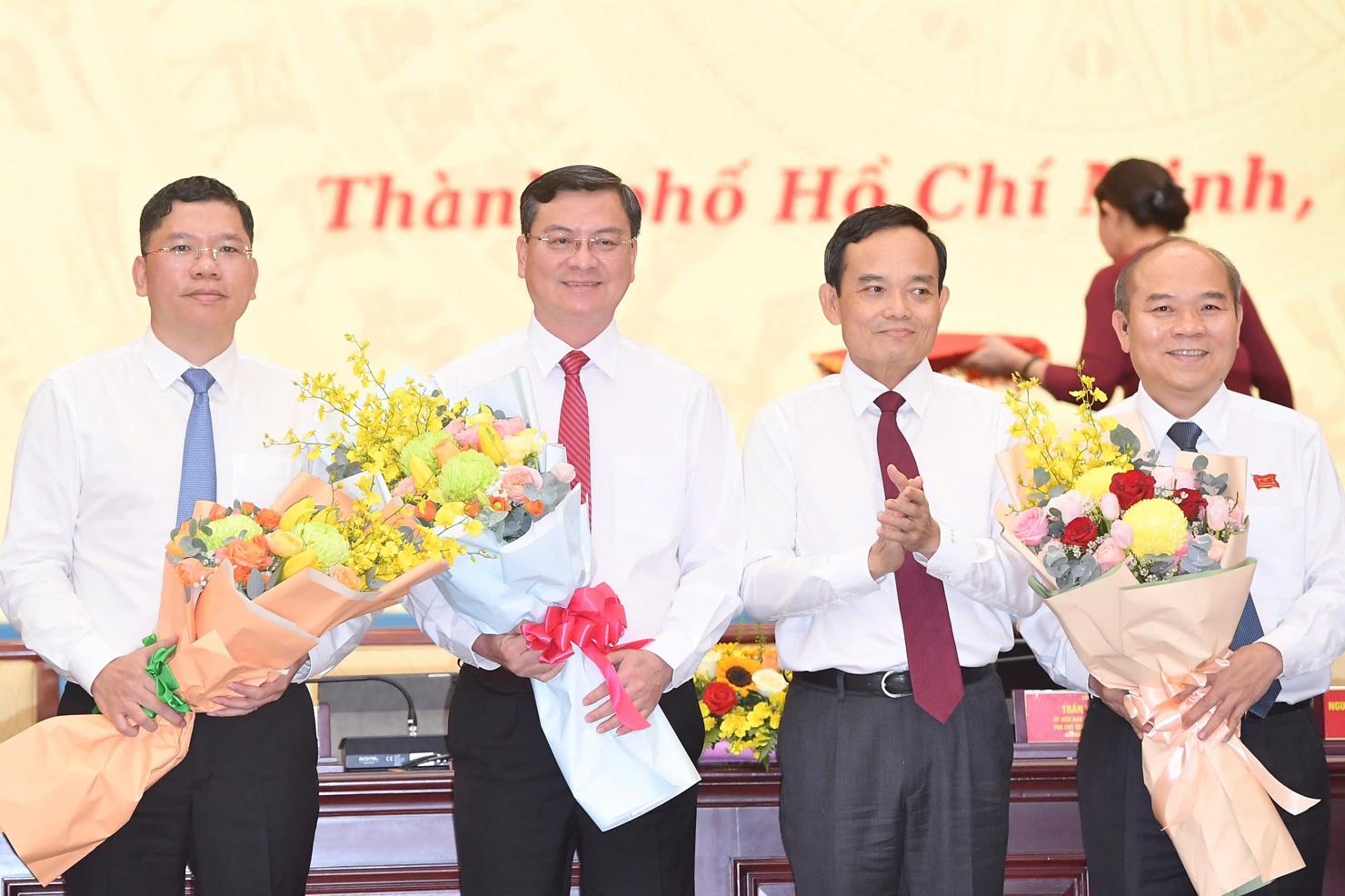 Bí thư Thành ủy TP. Hồ Chí Minh Trần Lưu Quang chúc mừng ba tân Phó chủ tịch UBND Thành phố. Ảnh: Phạm Thọ