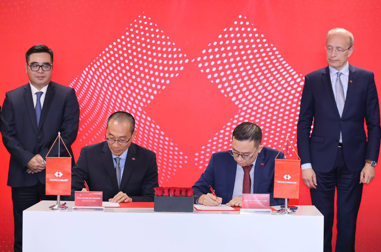 Đại diện Techcombank và Techcom Life ký kết thoả thuận trước sự chứng kiến của ông Ngô Việt Trung - Cục trưởng Cục Quản lý, giám sát bảo hiểm, Bộ Tài chính (trái) và ông Jens Lottner - Tổng Giám đốc Techcombank.