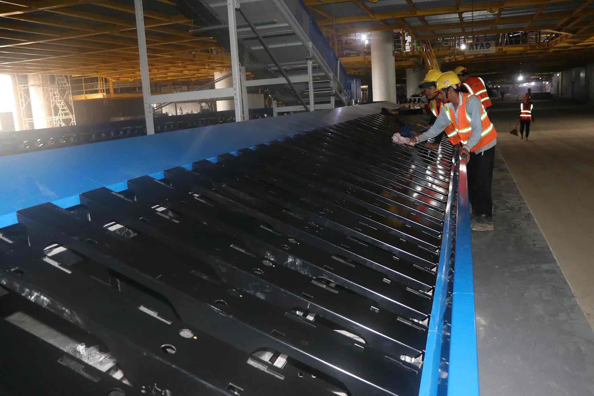 Công nhân vệ sinh hệ thống băng chuyền tại nhà ga hành khách sân bay Long Thành. Ảnh: HAC