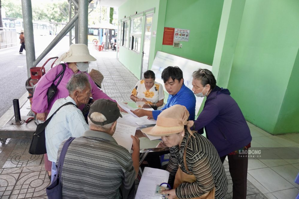 Nhân viên hướng dẫn người dân kê khai thông tin đăng ký thẻ giao thông công cộng. Ảnh: Như Quỳnh